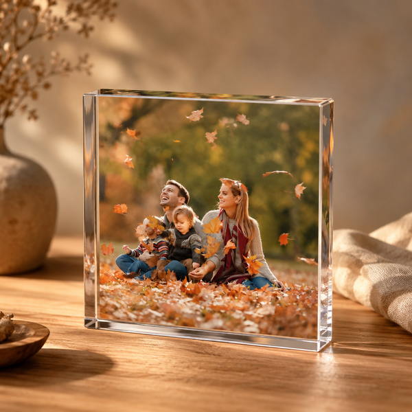 Akrylblock med familjefoto på ett träbord med höstlöv